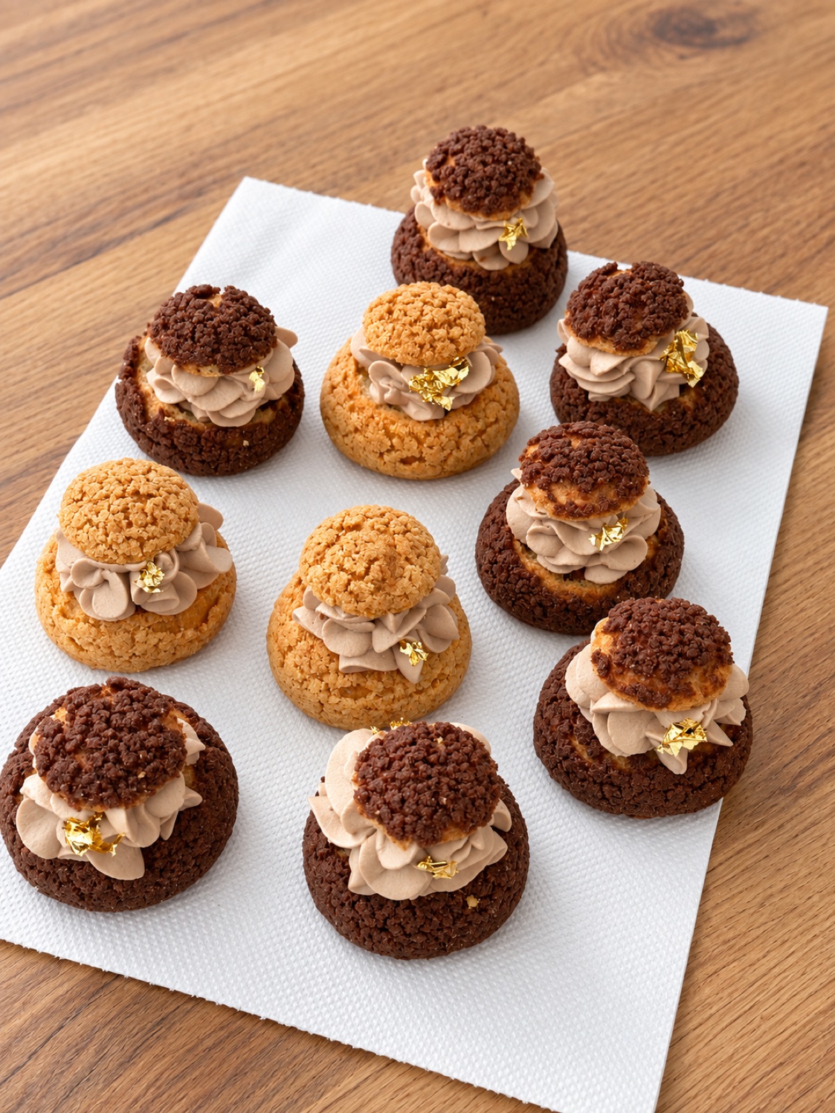 Des choux craquelin garnis de crème au chocolat et d'un éclat de feuille d'or